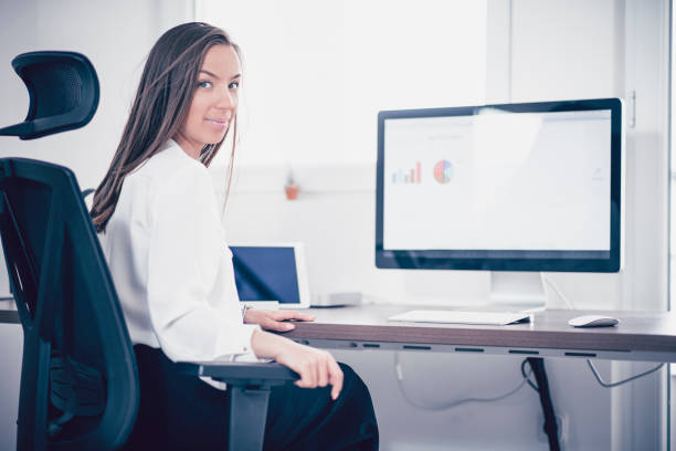 istock Cute Businesswoman Working on Computer in Modern Office and Posing 949736810