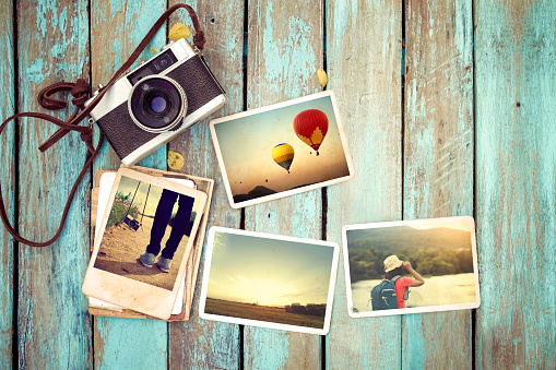 Photo album - concept of remembrance and nostalgia in summer journey trip on old wood plank with retro camera. vintage color style.