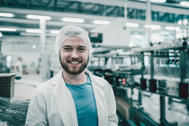 istock Young Handsome Smiling Scientist With Clipboard Posing in Factory 949740120