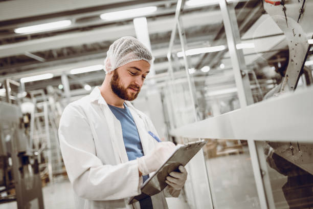 istock Scientist Writing on Clipboard and Working on Production Line 949743162