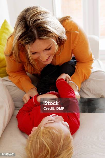 Madre Y Niño Pequeño Jugando En El Sofá En Casa Foto de stock y más banco de imágenes de 2-3 años - 2-3 años, 20-24 años, Acogedor