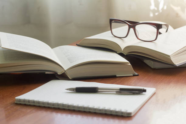 istock several books, glasses and a notebook with a pen on the table 949765144
