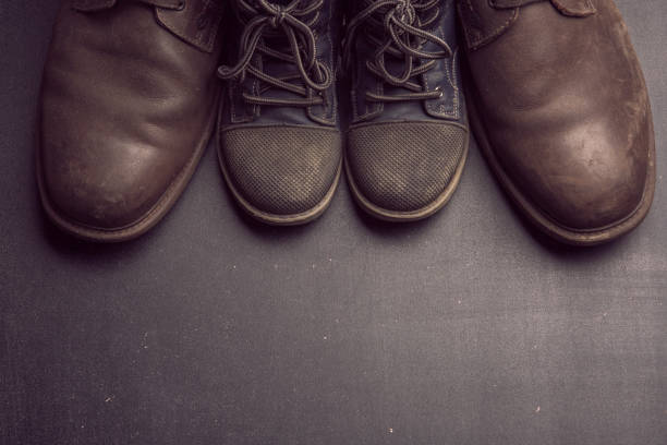 istock Daddy's boots and baby's shoes, fathers day concept. 949787340