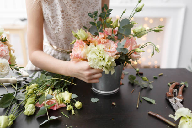 istock Master class on making bouquets for kids. Spring bouquet in metal ornamental flowerpot. Learning flower arranging, making beautiful bouquets with your own hands 949790454