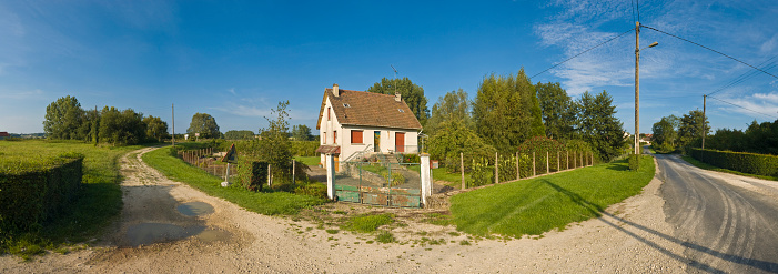 Meadow, trees and shrubs on the edge of the historic old town of Bad Homburg with single-family houses in summer weather