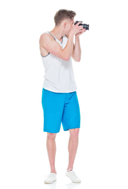 istock Young man wearing tank top holding camera 949834878