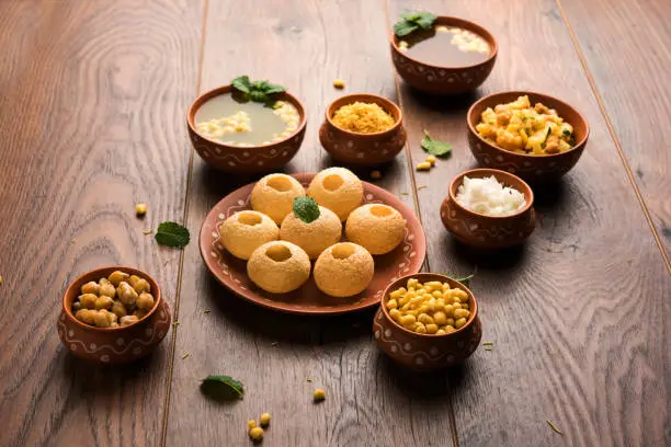 Pani Puri is Indian chat item served in a terracotta bowls and plate