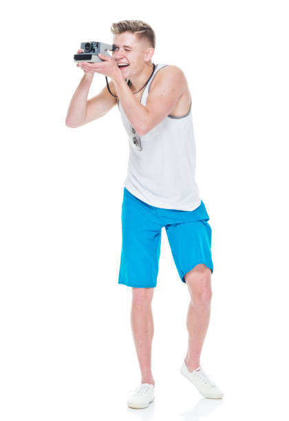 istock Young casually dressed man taking photos with a polaroid camera 949845320