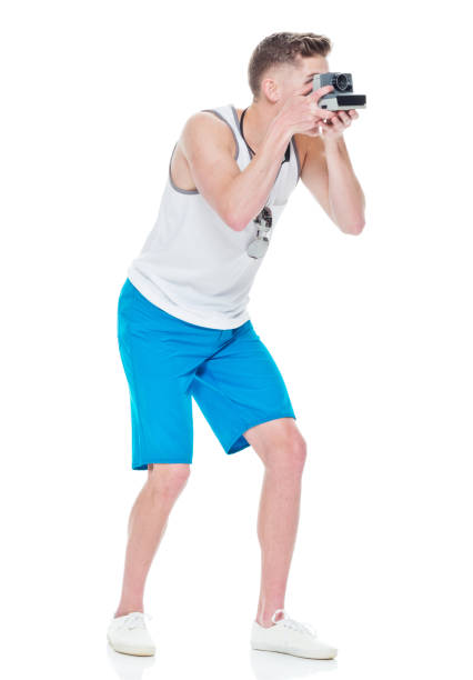 istock Young casually dressed man taking photos with a polaroid camera 949845584