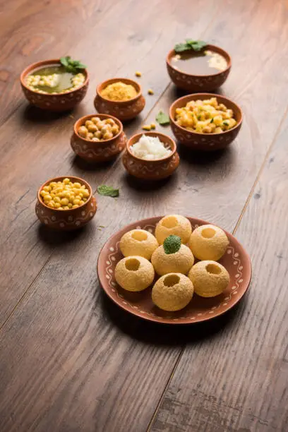 Pani Puri is Indian chat item served in a terracotta bowls and plate
