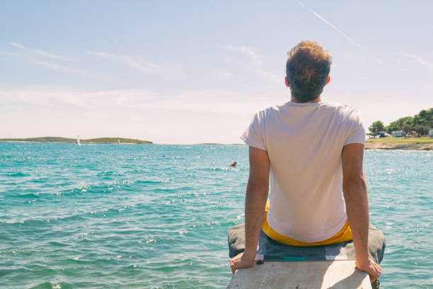 istock Tourist handsome man enjoying the view on the beach. Summer concept. 949850154
