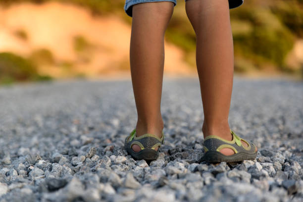 petit enfant marche sur le sentier de gravier - road long dirt footpath photos et images de collection