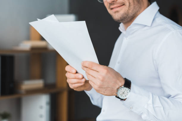 istock Smiling businessman studying papers in office 949851062