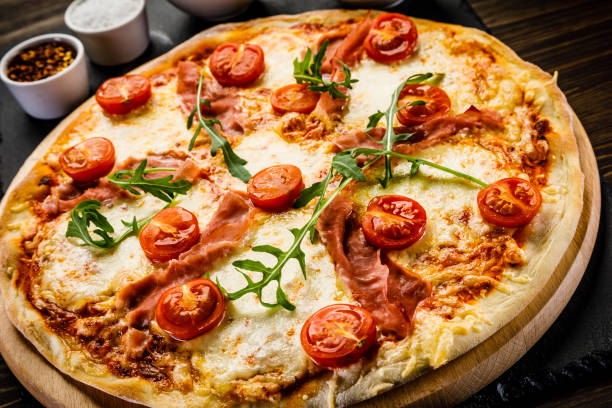 istock Pizza margherita with arugula on wooden background 949851648