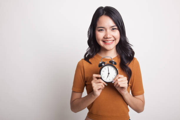 istock Young Asian woman smile with a clock. 949856968
