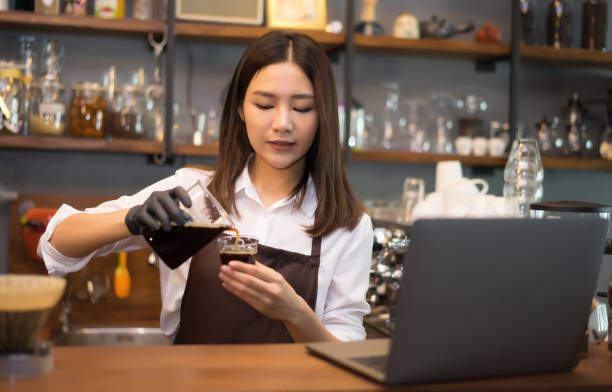 barista woman preparing brew ice drip coffee behind the counter in the coffee shop, woman learning how to make a coffee. - espresso women cup drink imagens e fotografias de stock