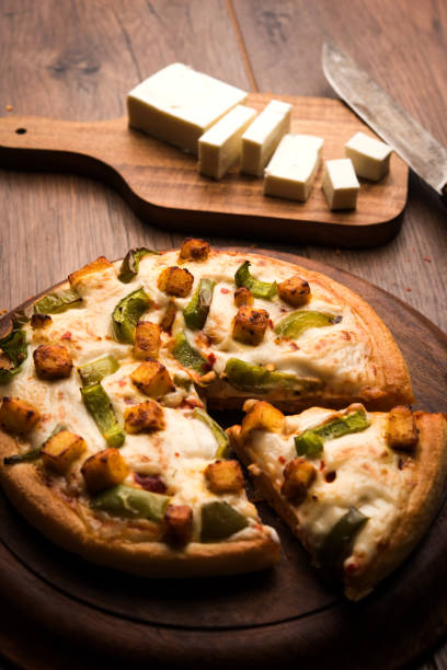 istock Indian Paneer Pizza with fresh cottage Cheese cubes and white sauce 949871596