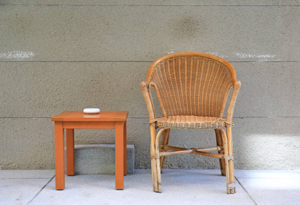 istock Rattan chairs with mini wooden table against rug cement wall. 949871834