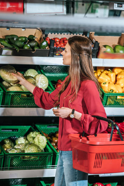 istock woman choosing fresh raw vegetables in grocery store 949872218