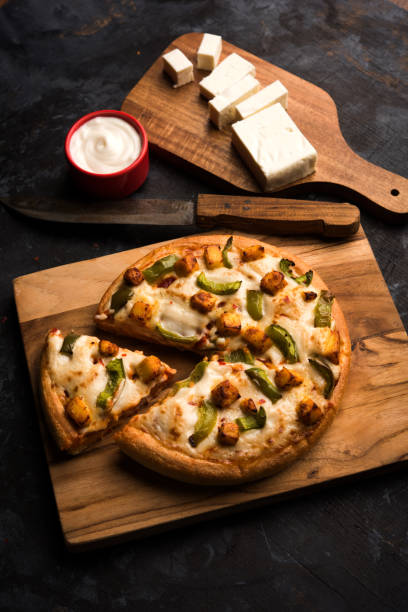 istock Indian Paneer Pizza with fresh cottage Cheese cubes and white sauce 949877348