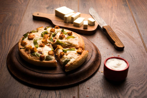 istock Indian Paneer Pizza with fresh cottage Cheese cubes and white sauce 949880726