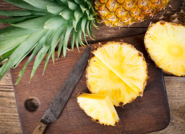 istock sliced pineapple on wooden background 949895784