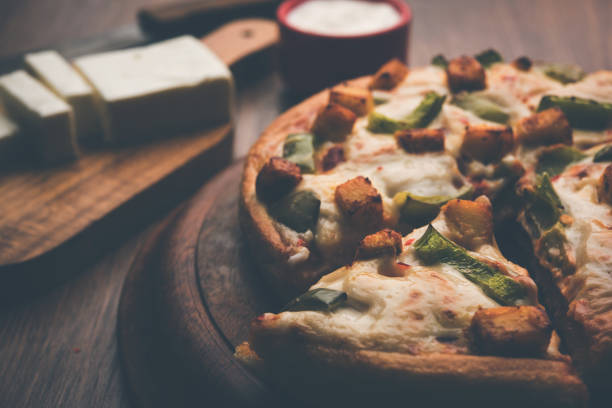 istock Indian Paneer Pizza with fresh cottage Cheese cubes and white sauce 949899786