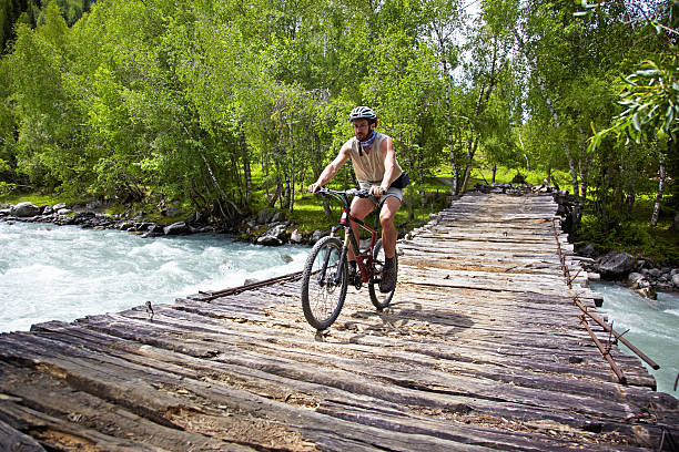 istock Mountain biker goes on old wooden bridge 94990189
