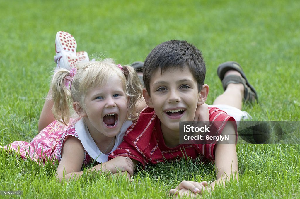 Sorridente menino e uma menina na grama - Foto de stock de 10-11 Anos royalty-free