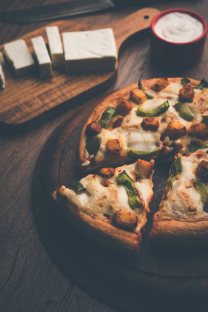 istock Indian Paneer Pizza with fresh cottage Cheese cubes and white sauce 949910472