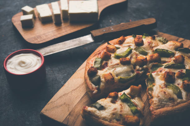 istock Indian Paneer Pizza with fresh cottage Cheese cubes and white sauce 949925620