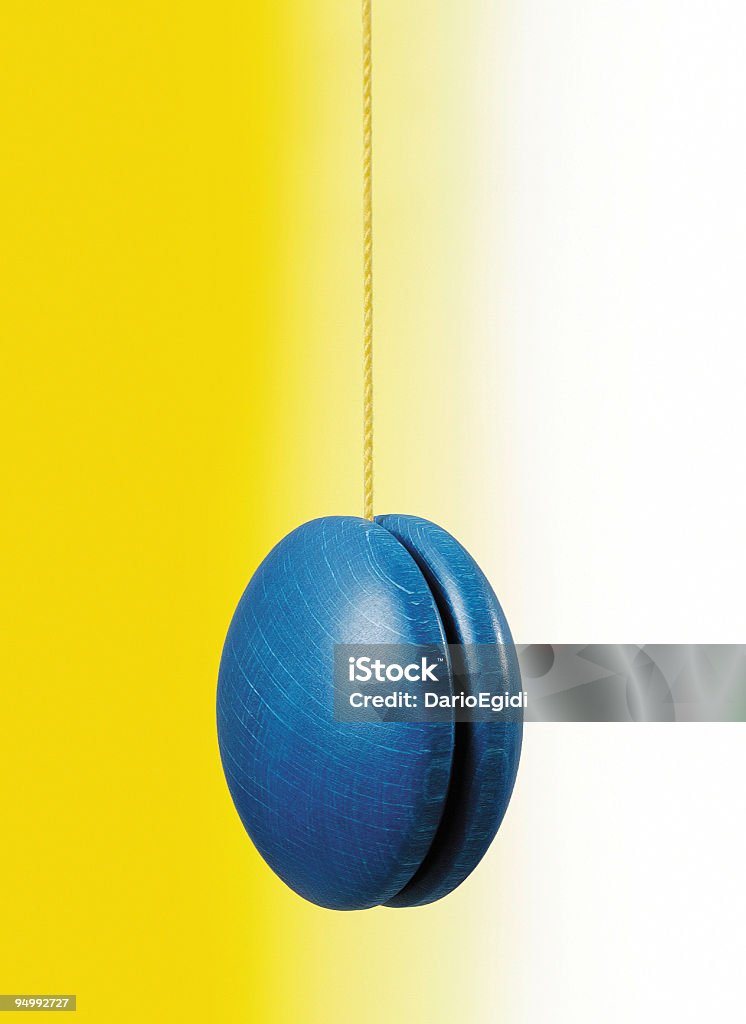Blu appesa yo-yo su bianco e sfondo giallo - Foto stock royalty-free di Yo-yo
