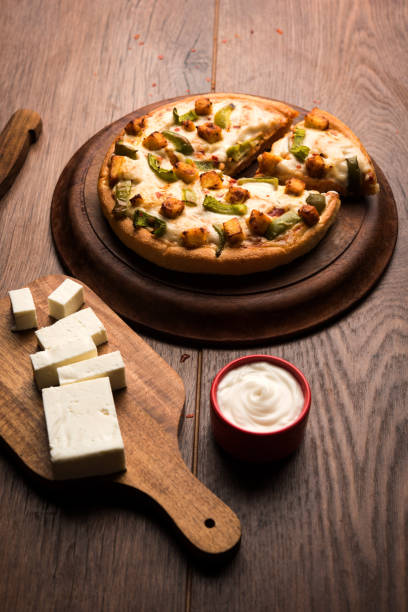 istock Indian Paneer Pizza with fresh cottage Cheese cubes and white sauce 949929098
