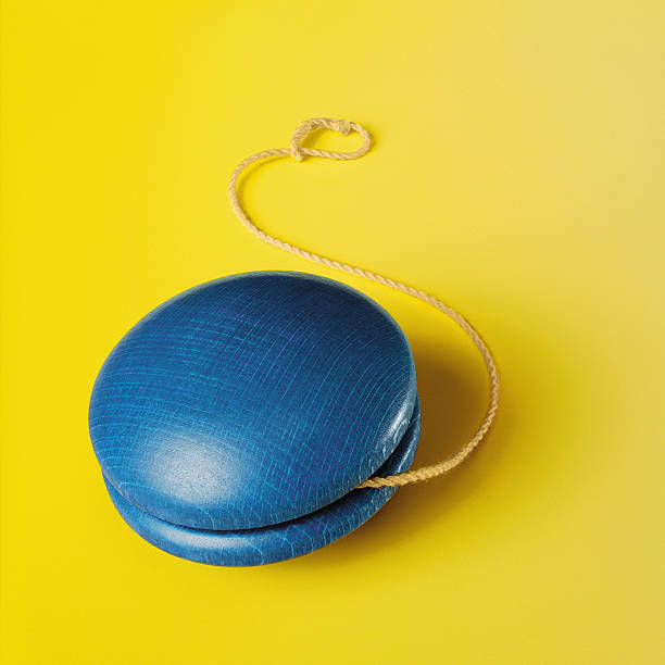 Blue yo-yo on yellow background stock photo