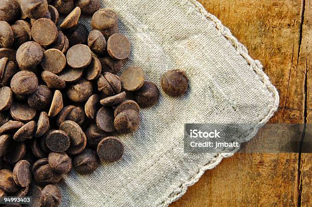 Chocolate Chips On A Wood Table Stock Photo - Download Image Now - Candy, Chocolate, Chocolate Chip