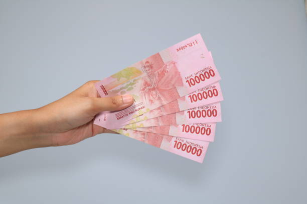 frau hand zeigt indonesische rupiah geld - indonesian currency stock-fotos und bilder