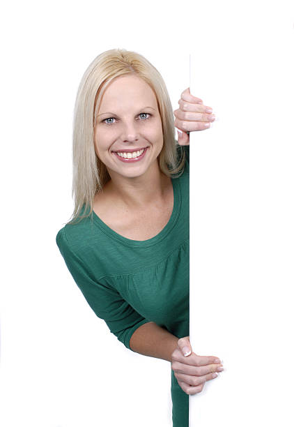 istock Friendly blonde girl peeking round a white board 94994539