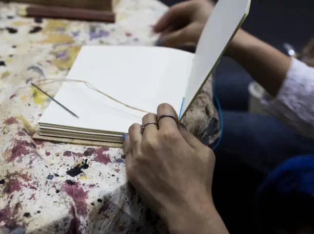 women worker binding pages in for handmade book