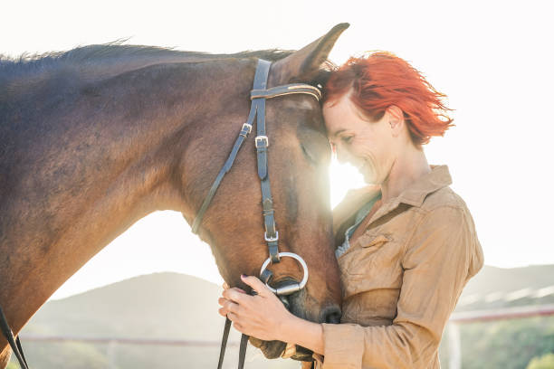 Young farmer woman hugging her horse - Concept about love between people and animals - Focus on girl eye Young farmer woman hugging her horse - Concept about love between people and animals - Focus on girl eye equestrian event photos stock pictures, royalty-free photos & images