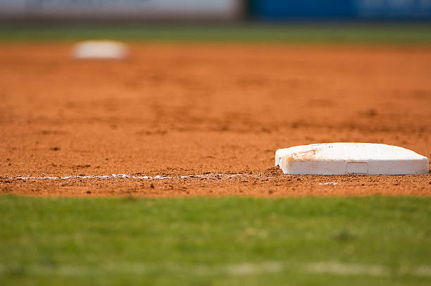 infield au terrain de baseball à un match de baseball - baseball diamond baseball baseline grass photos et images de collection