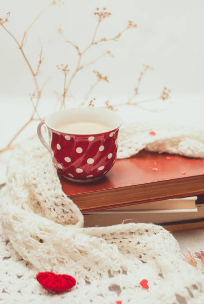istock Cup of coffee with warm knitted scarf 949971178