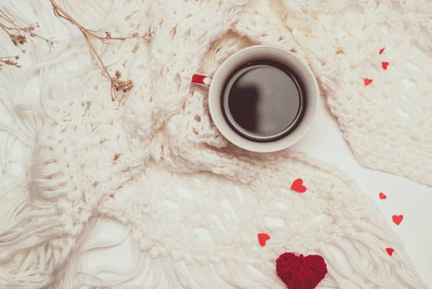 istock Cup of coffee with warm knitted scarf 949971286