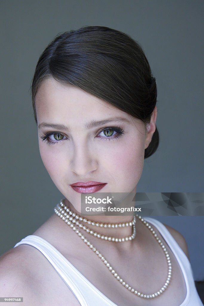 Retrato de una mujer joven usando perlas, gris, blanco - Foto de stock de 18-19 años libre de derechos
