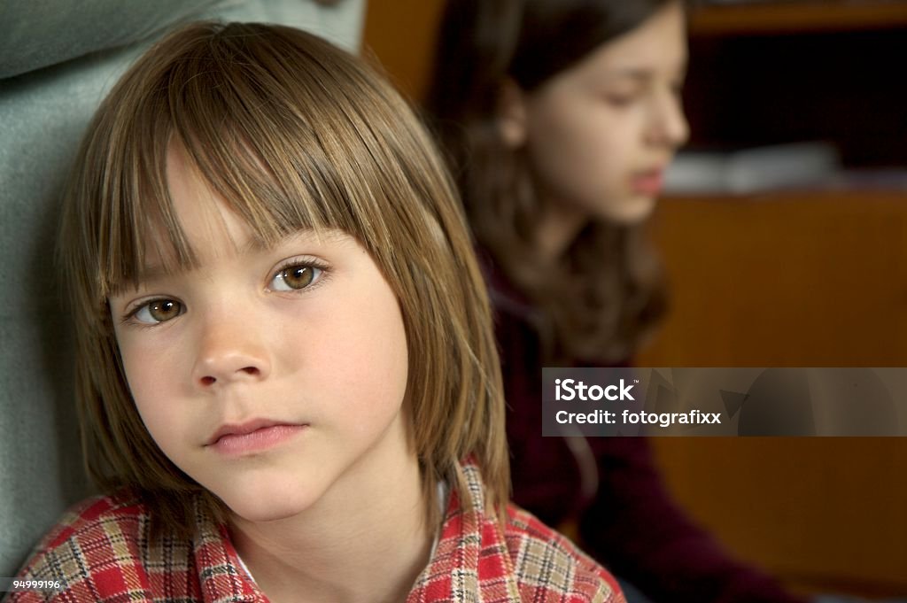 Ritratto di un ragazzo serio, è triste, sorella in background - Foto stock royalty-free di 6-7 anni