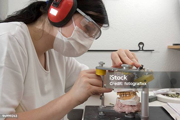 Foto de Feminino Dental Técnico Com Máscara Cirúrgica Prepara Dentaduras e mais fotos de stock de Adulto