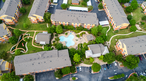 Aerial Drone view looking down on Apartment Complex residential buildings around Swimming Pool and Urban Dog Park Austin , Texas , USA