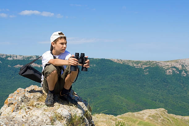 niño con binoculares - pursuit binoculars mountain sky fotografías e imágenes de stock