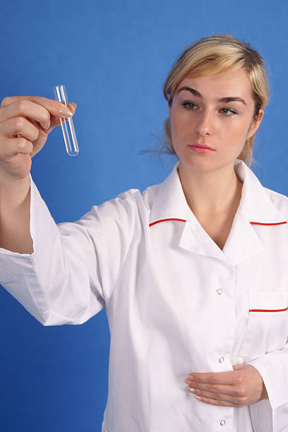 Female researcher looking at test tube stock photo