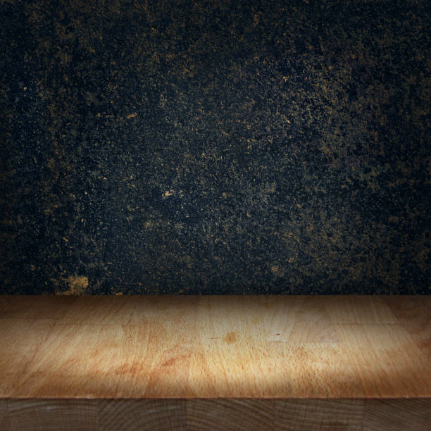 istock Wooden kitchen top table with bright light spot and dark stone background 950019284