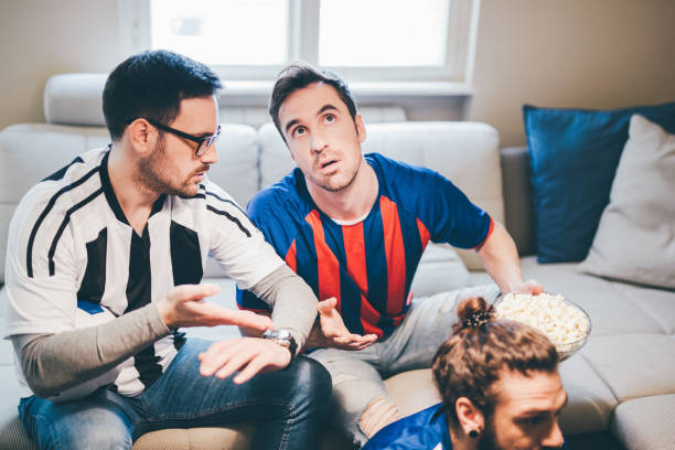 istock Male football supporters talking while watching the game on TV 950020042